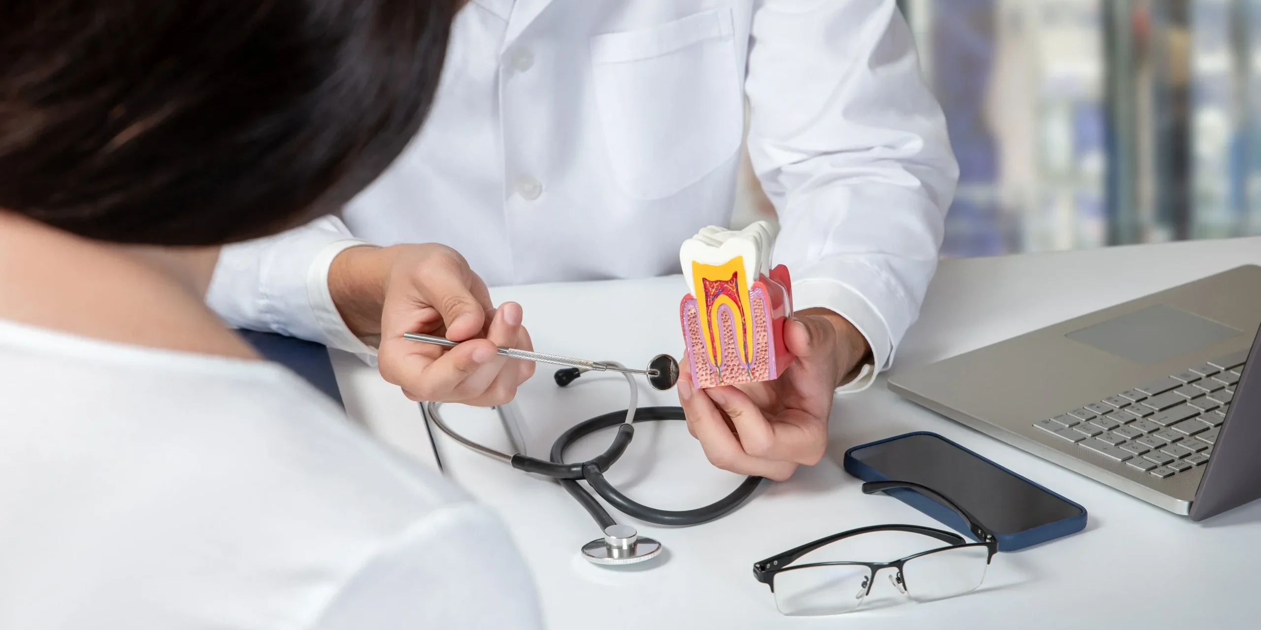 A woman seated at a dental clinic while a dentist speaks to her