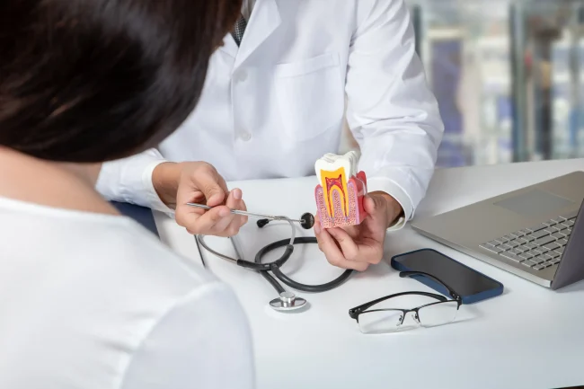A woman seated at a dental clinic while a dentist speaks to her