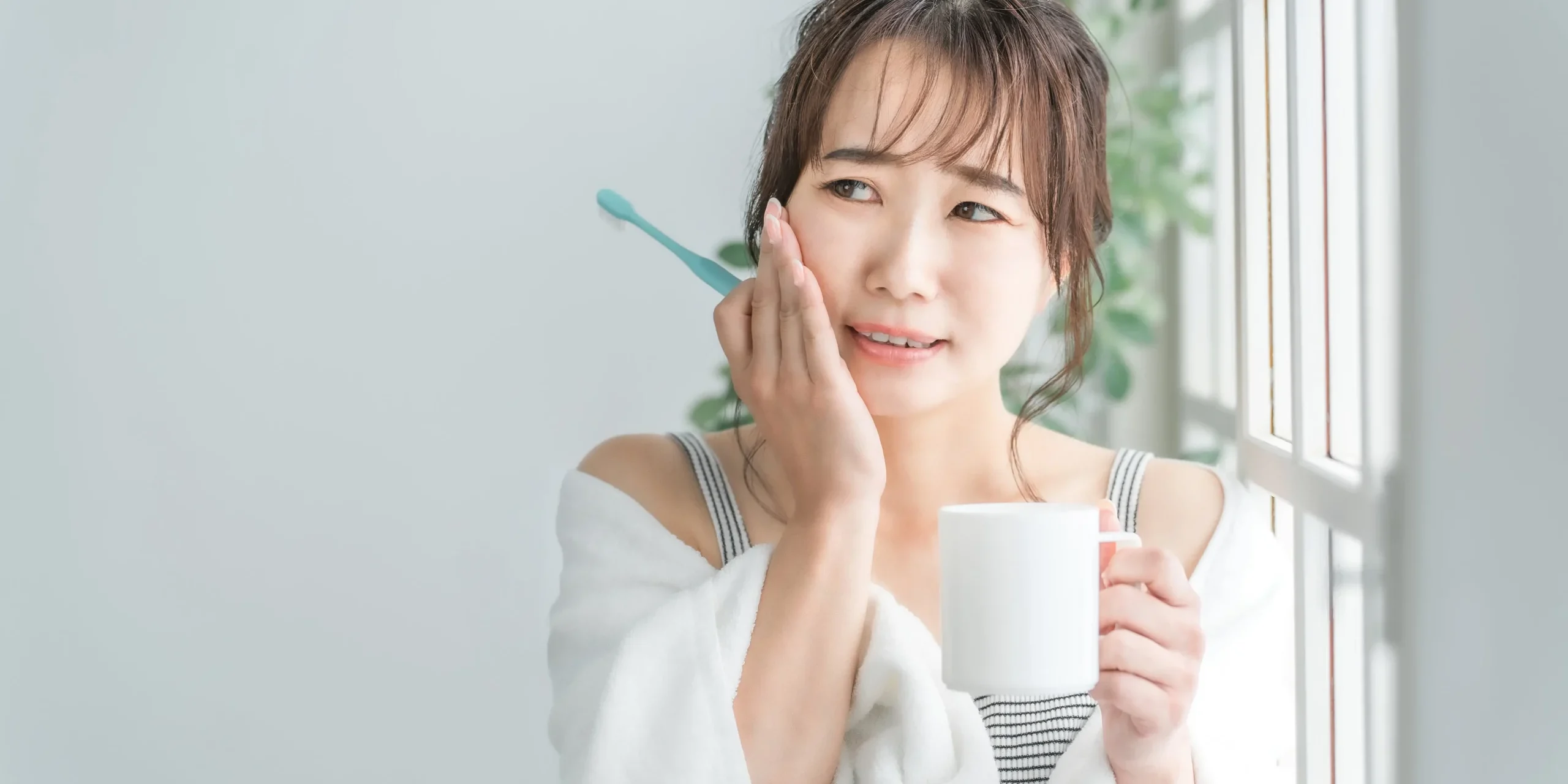 Woman with toothache A woman holding her cheek while wincing in pain