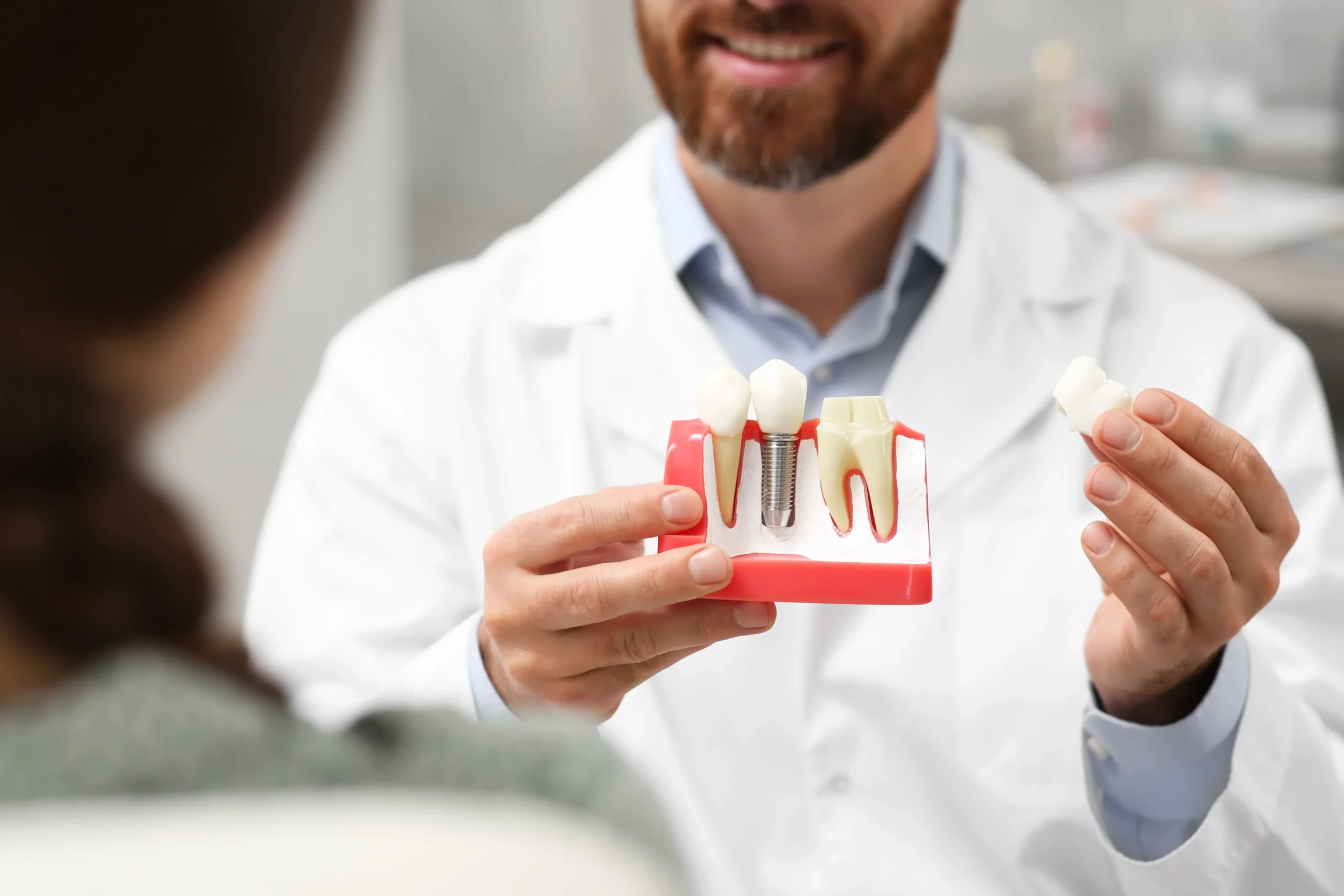Dentist explains options for tooth replacement to a female patient