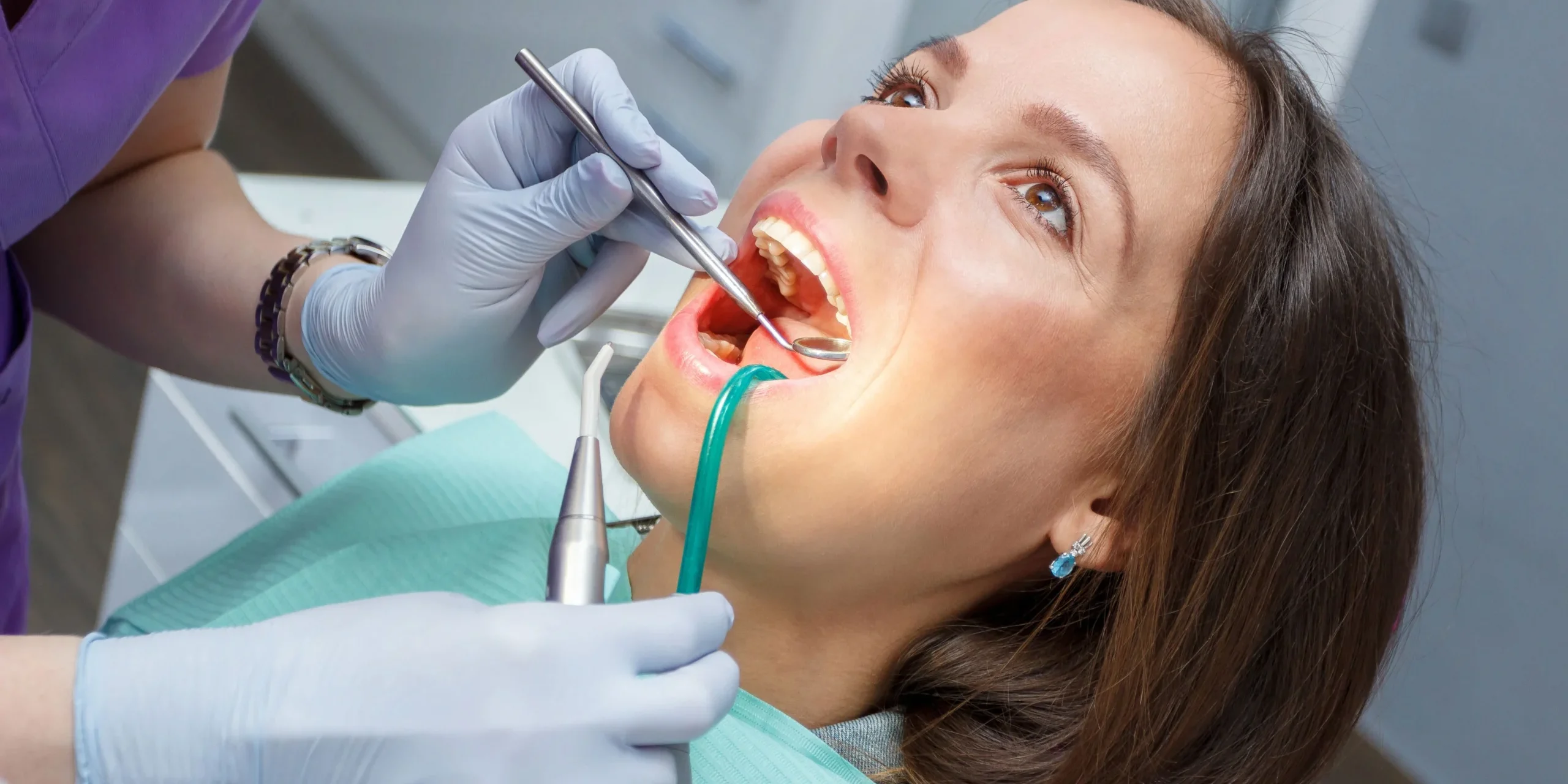 Dentist checks a female patient's teeth