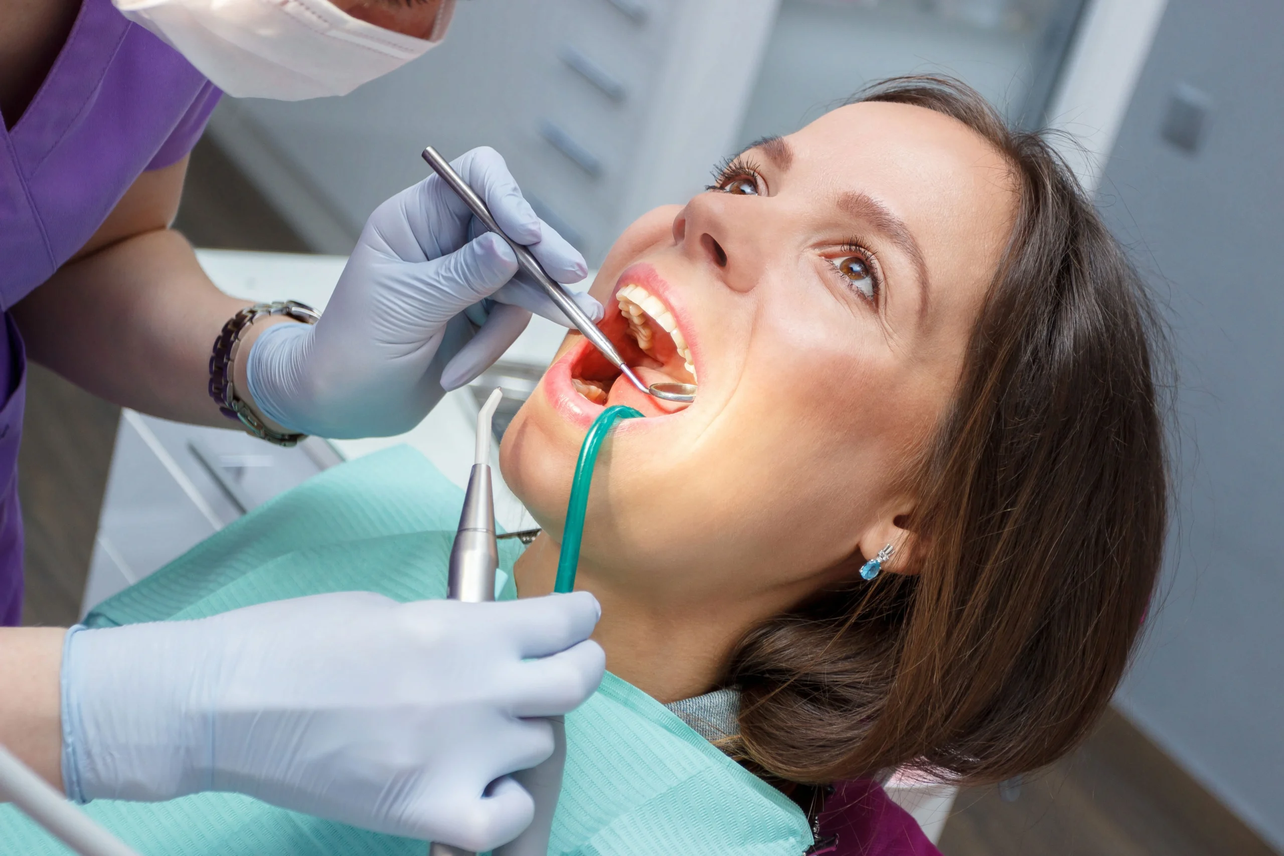 Dentist checks a female patient's teeth