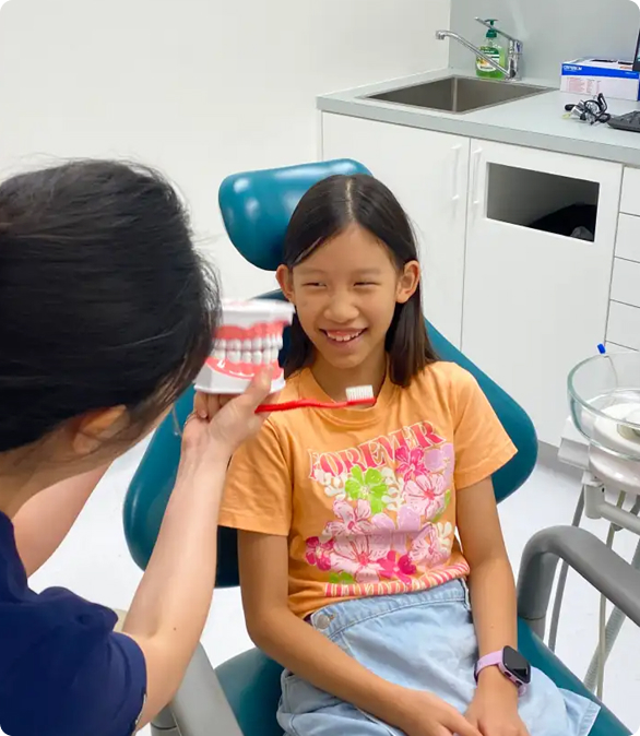 Dentist showing a teeth structure to a girl