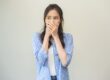 woman with bad breath covering her mouth